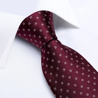 Close-up of burgundy silk tie with small geometric diamond pattern