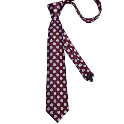 Full-length burgundy polka dot silk tie on white background