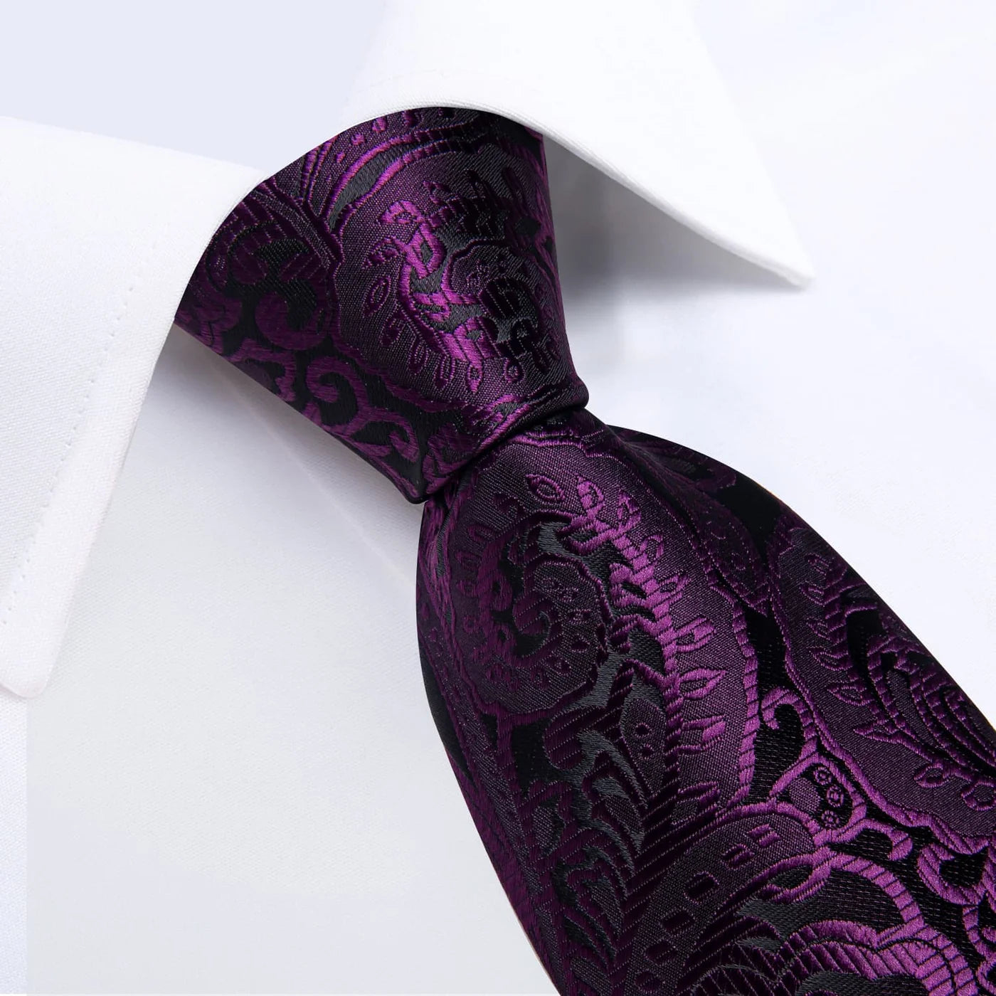 Close-up of purple and black paisley silk tie with woven floral pattern
