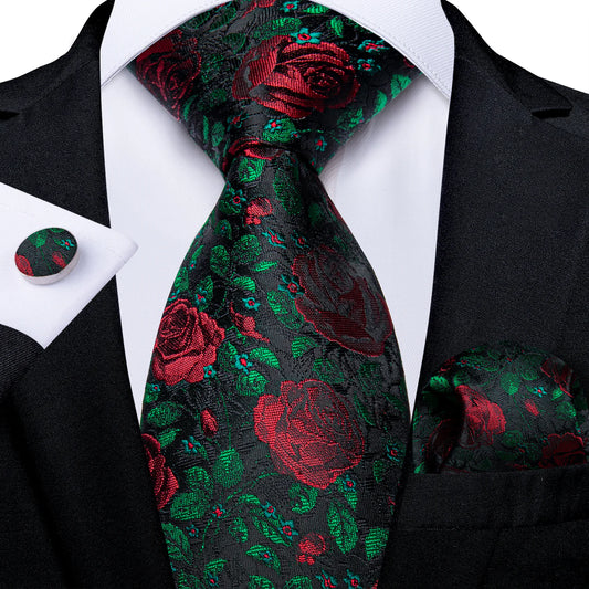 black silk tie with red rose floral pattern and green accents styled with suit pocket square cufflinks