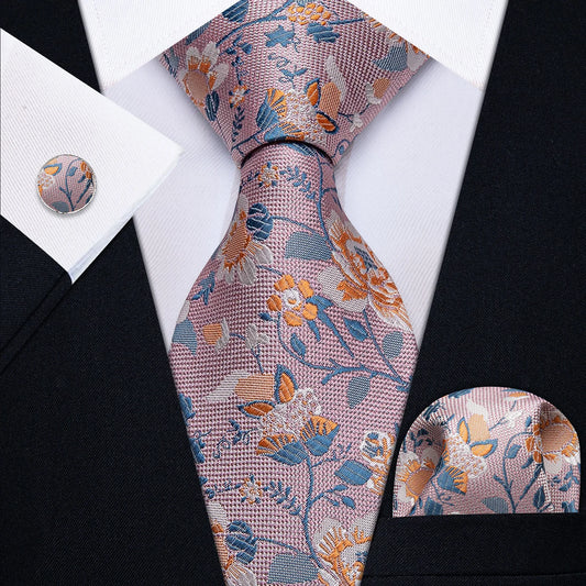 Pink floral tie set with blue and orange accents, matching pocket square and cufflink worn with black suit